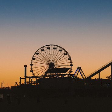 FOR COMMS TEAM USE ONLY - Pier and ferris wheel silhouetted against an orange dusky sunset