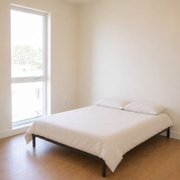 Simple bed in affordable housing apartment room