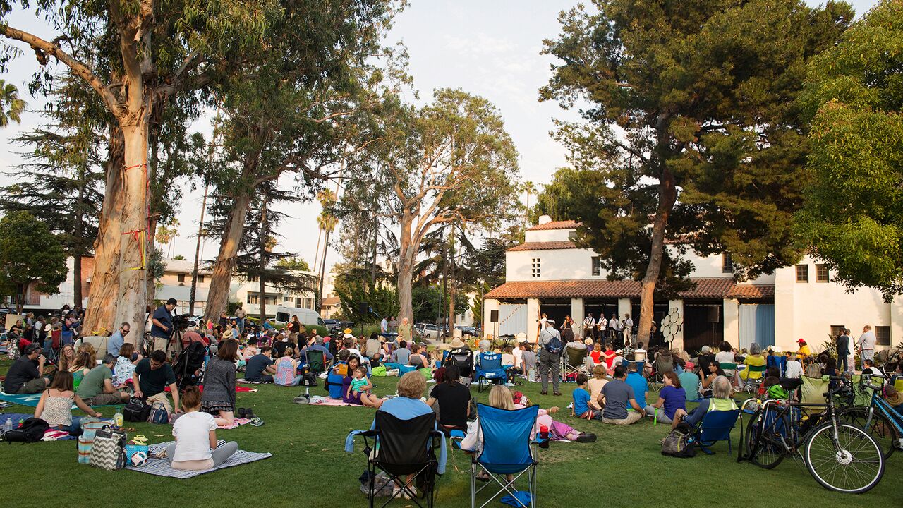 A view of a concert in Reed Park with the Miles Memorial Playhouse in the background