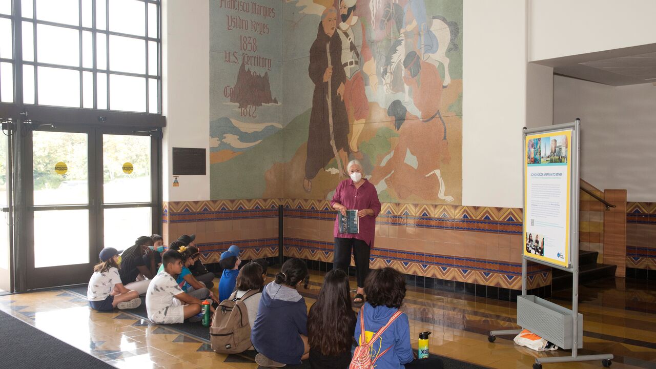 Artist Glenna Avila Speaks with a Group of Children in the Historic City Hall Lobby