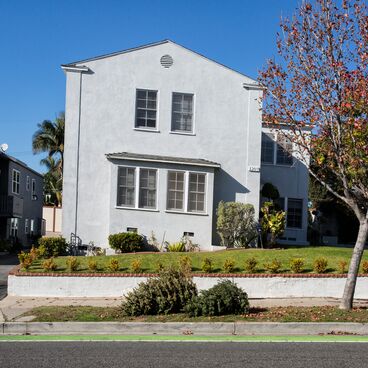 Old Christmas Trees in front of a White Building  Ready for Pick Up