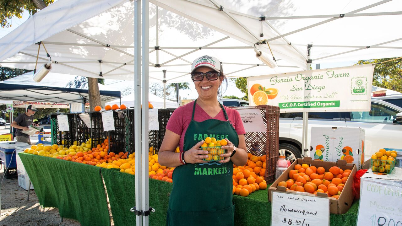 Vendor Holding Citrus at Virginia Park Farmers' Market