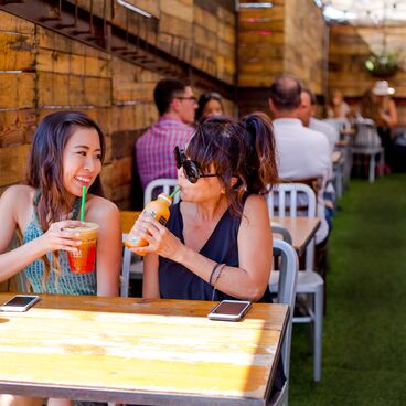 Mother and Daughter Drinking Juice at Outdoor Tables