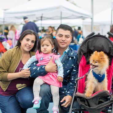 A family and their dog pose at an event at Virginia Avenue Park