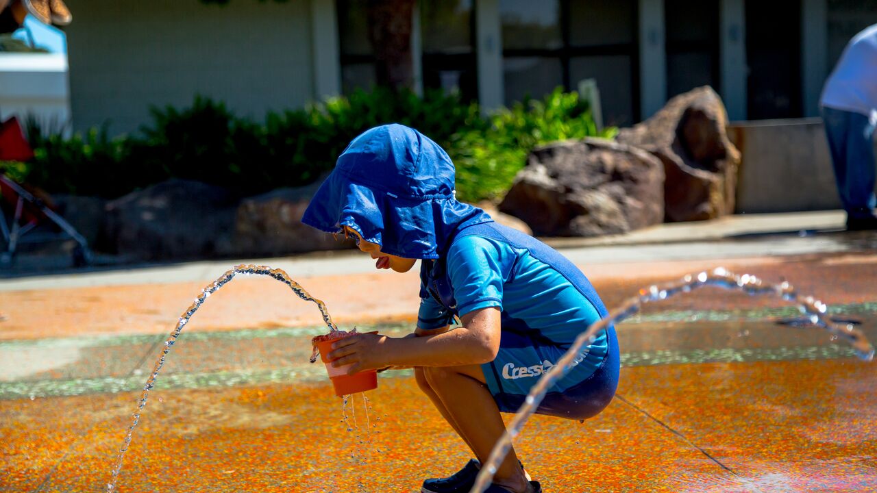 Young Boy With Bucket Playing in the Splash Pad
