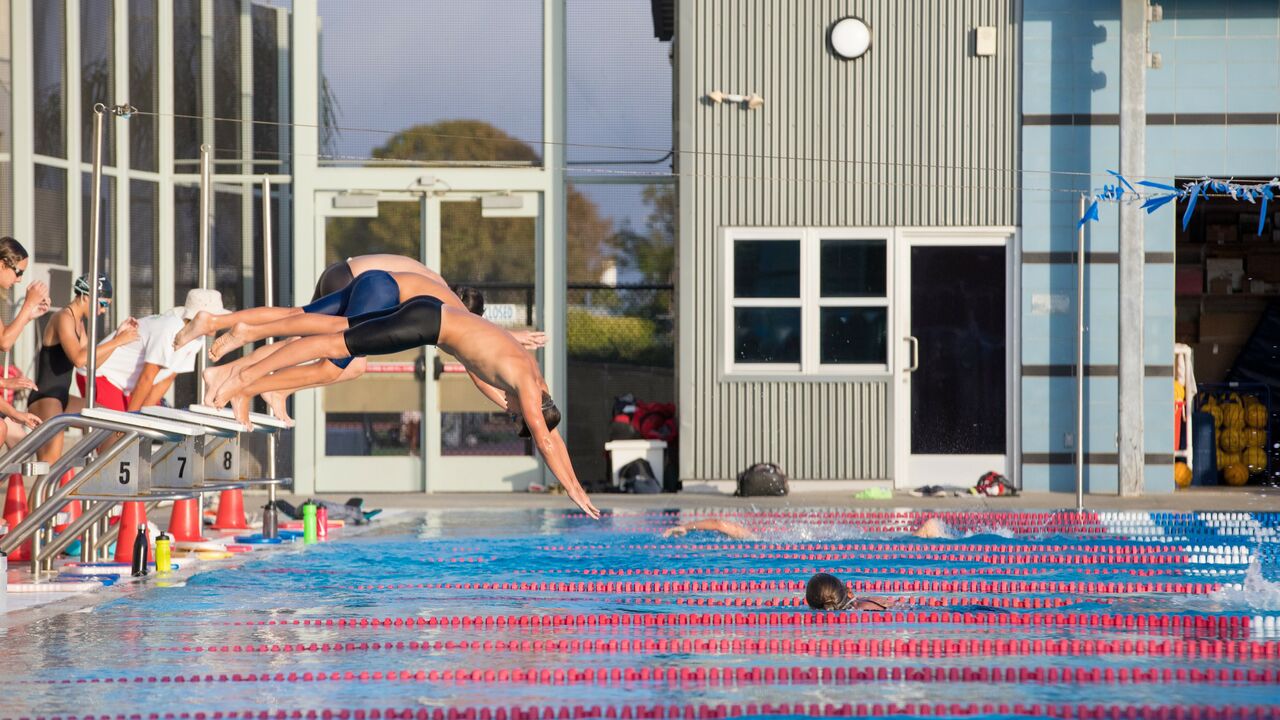 Youth swim team diving into  pool at Santa Monica Swim Center