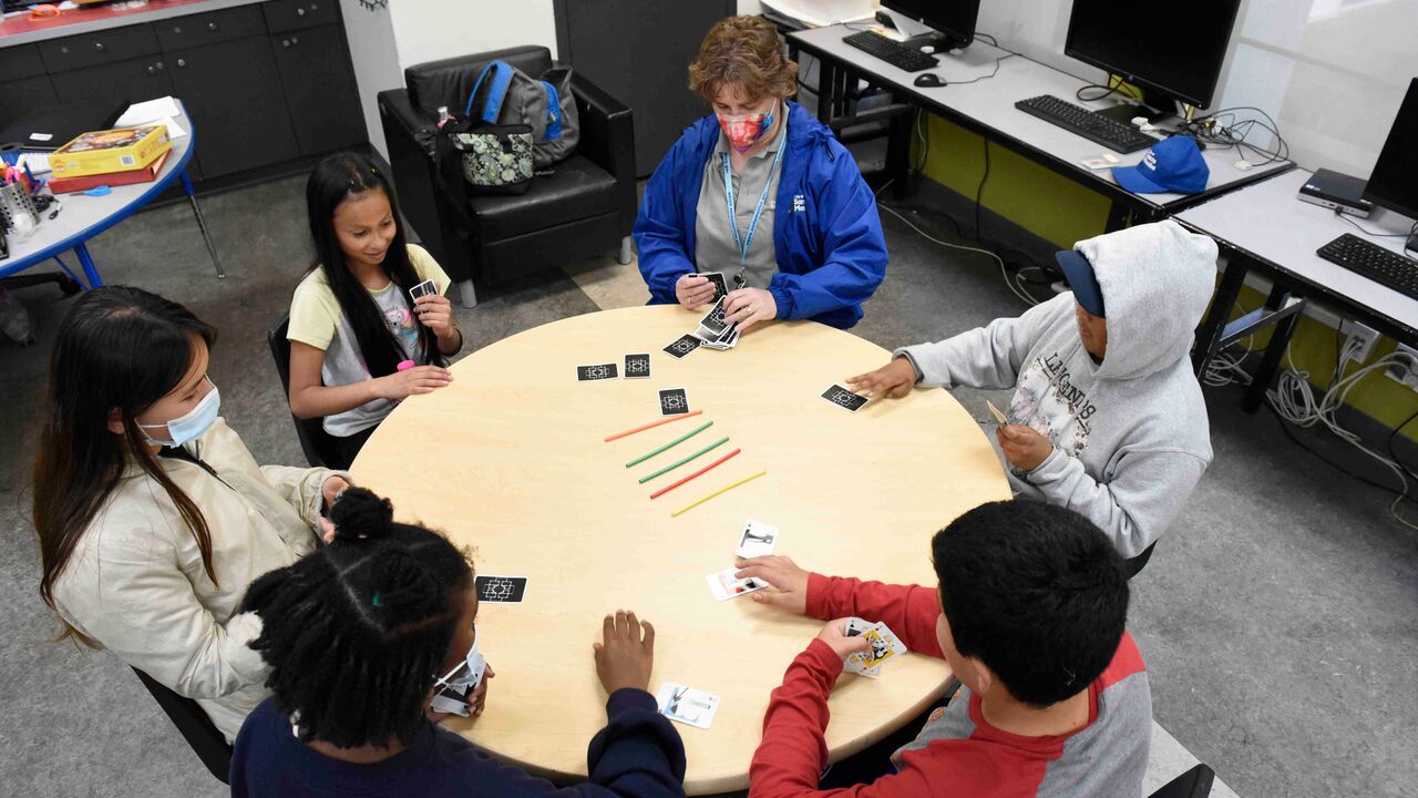 Overhead picture of teacher playing table game with a group of kids