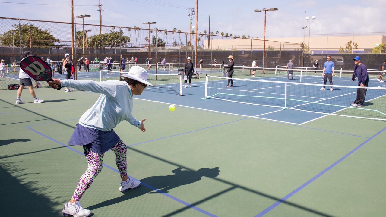 Person serving a pickleball at Memorial Park tennis courts