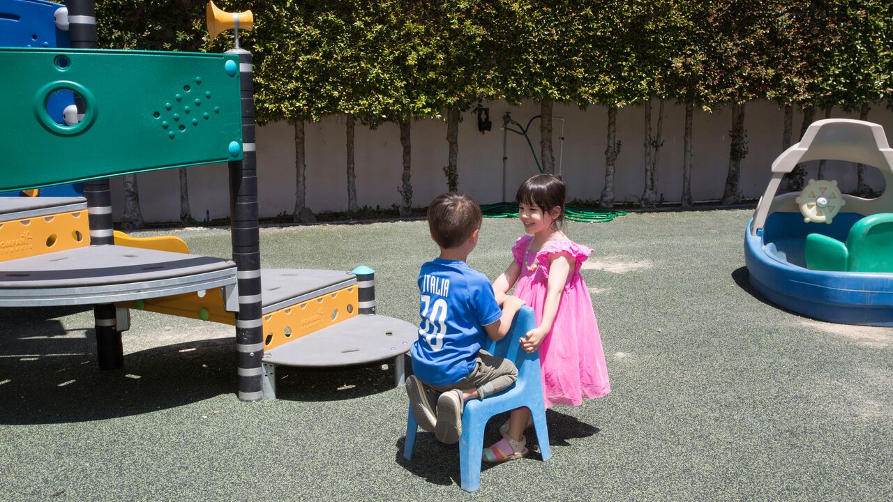 Two children talking at Providence Preschool playground
