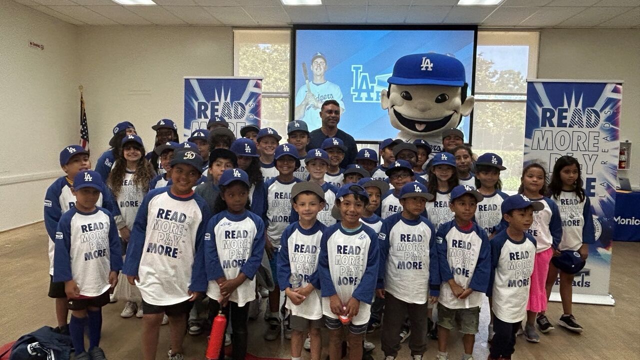 Youth in blue and white shirts that say Read More Play More and Dodger caps at a city summer camp