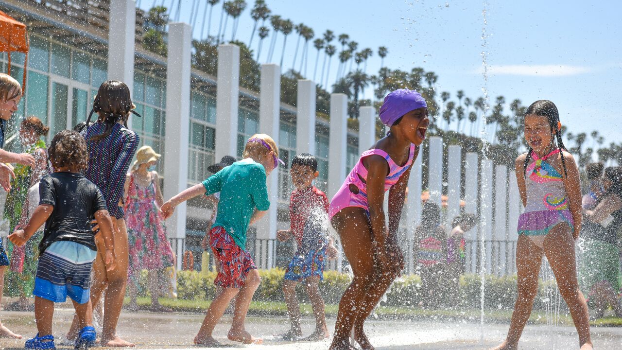 Children play at the splash pad at the Annenberg Community Beach House