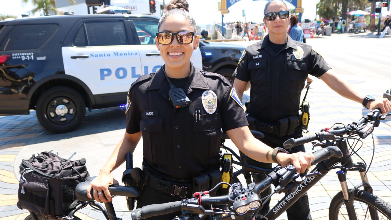 Female Police Officers with Bikes, Police Car and Santa Monica Pier Entrance in the Background