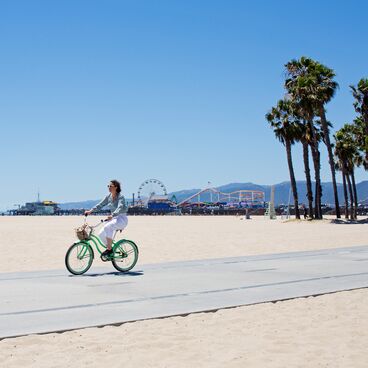Bicyclist on the Beach Bike Path with Santa Monica Pier and Palm Trees in the Background