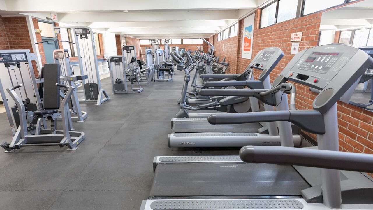 Fitness room with cardio machines with additional equipment in the background