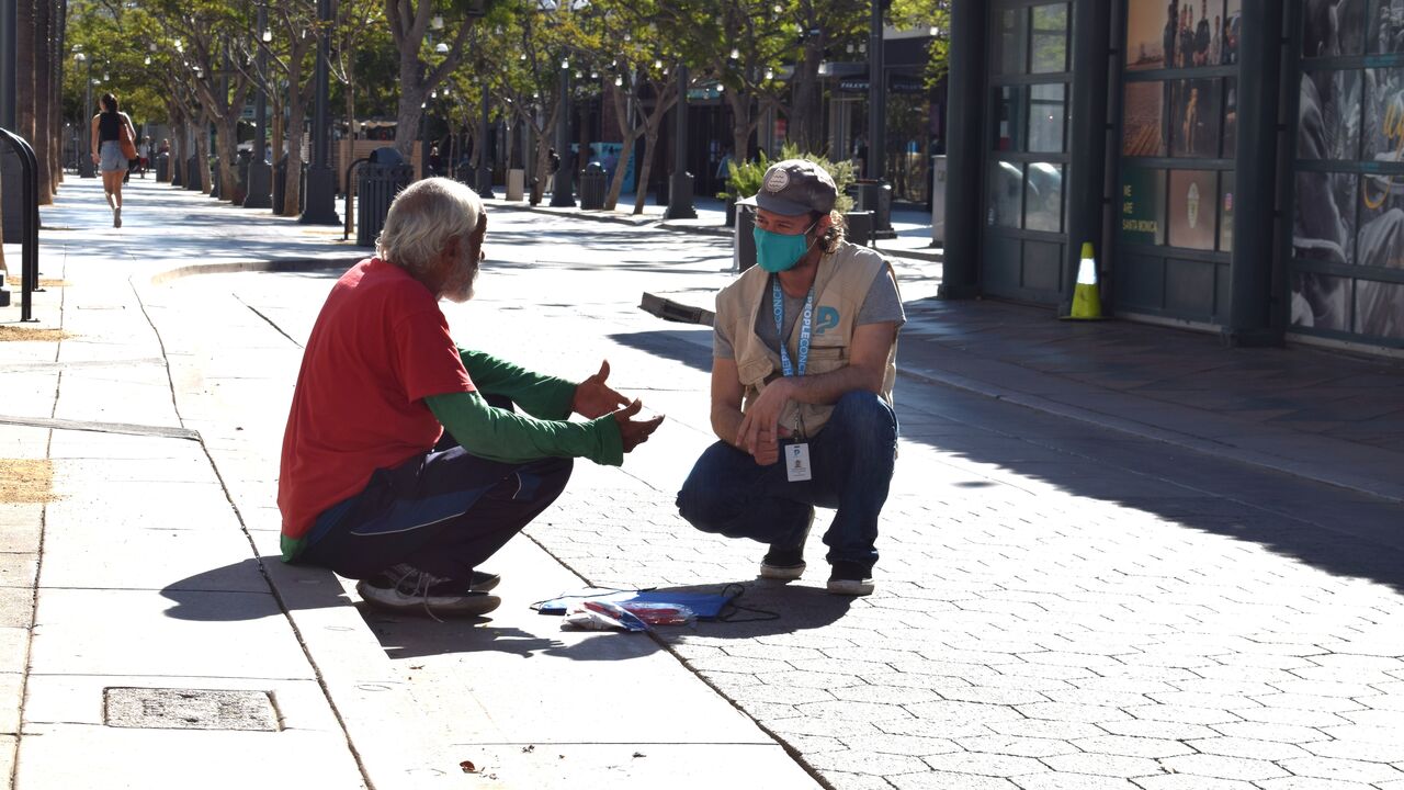 Volunteer makes contact with individual experiencing homelessness. 