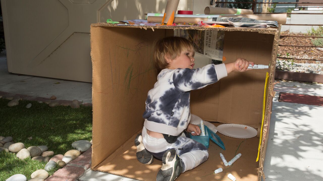 Child Painting inside Cardboard Box at Sunny Days Preschool