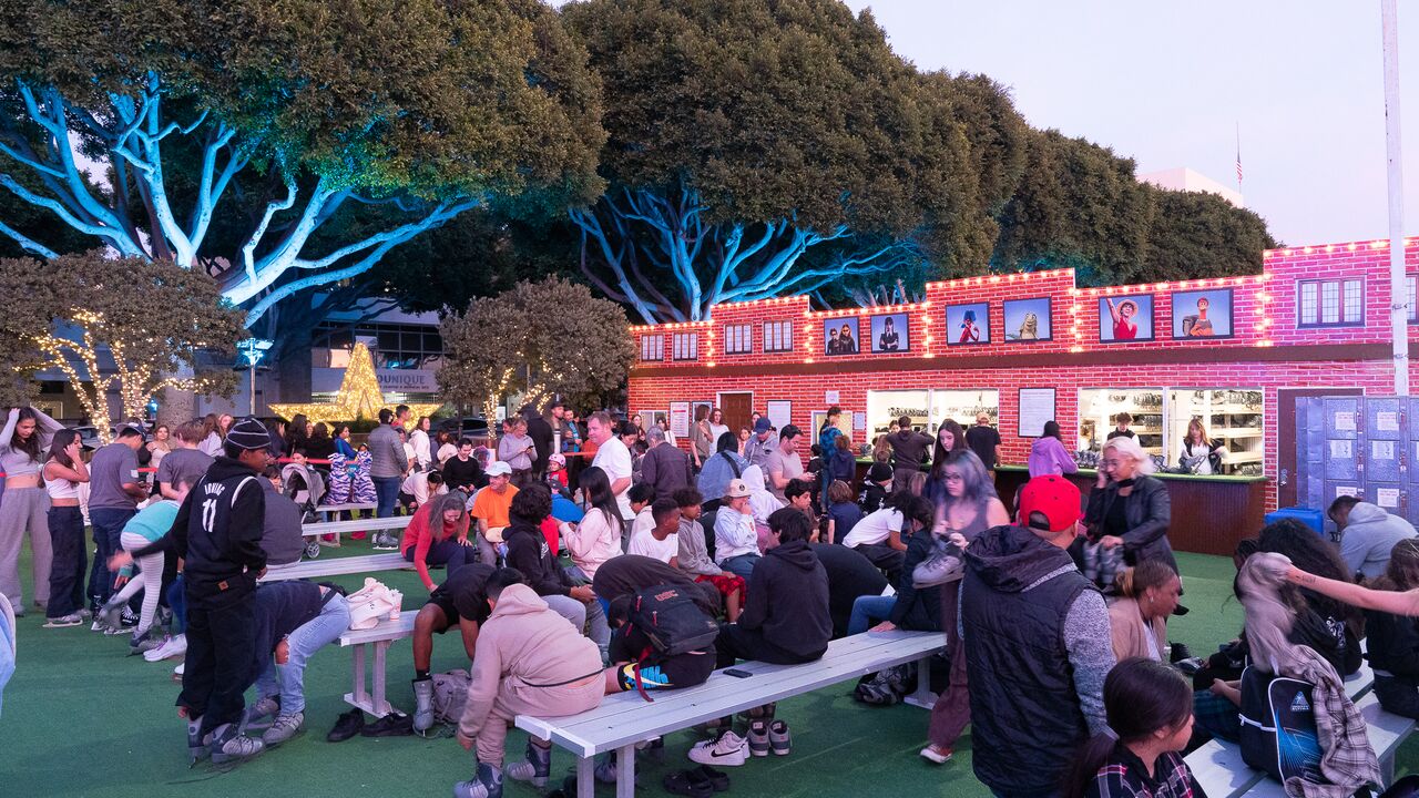 Crowd sitting on the benches at Ice with lit up trees in background