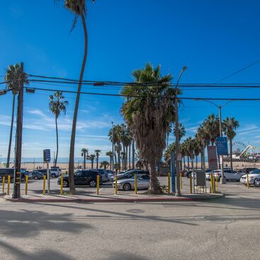 Entrance to Lot 2 South with Parked Cars, Trees, Blue Skies, the Santa Monica Pier and Beach in the Backgraound