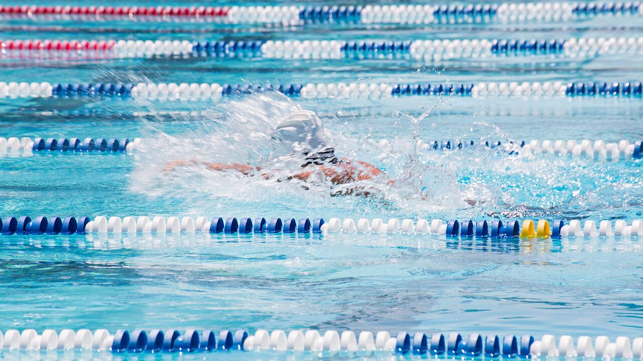 Butterfly stroke swimmer splashing water during swim at the Swim Center