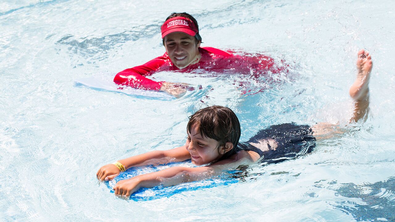 Swim instructor working with young girl in the pool at the Swim Center